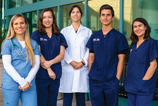 nurses and physicians wearing scrubs with all of us logo standing in front of ACTRI building